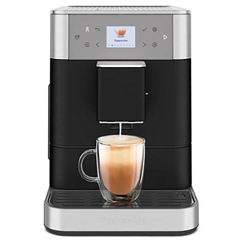 KitchenAid KES8556BK fully automatic espresso machine in black, brewing a latte into a clear glass mug