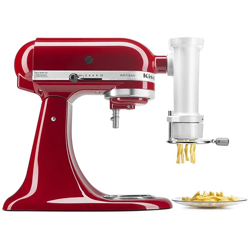 KitchenAid KSMPEXTA gourmet pasta press attached to a red stand mixer, extruding fresh pasta onto a plate