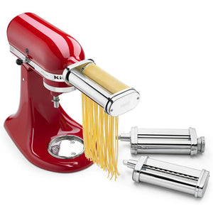 KitchenAid KSMPRA 3-piece pasta roller and cutter set on a red stand mixer cutting fresh fettuccine