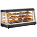 Alpha APDW-48 deluxe glass display 48-inch food warmer shown stocked with baked goods on three lit shelves