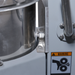 Alpha AVP-10 10 qt planetary stand mixer, close-up of the bowl arm clamp and gear warning label on the column