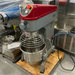 Certified used Alpha AVP-20 20 qt planetary stand mixer on a pallet, angled right view of the grey column and bowl