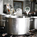 Bios DT155 digital deep fry candy thermometer in use, clipped to a large stainless steel stock pot on a kitchen range