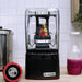 Blendtec Nitro X Stealth blender with sound enclosure in use blending fruit on a kitchen counter beside a red drink