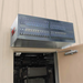 Curtron S-IBD Series insect back door aluminum air curtain mounted above a rear service door, angled view of the grille