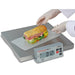 Detecto PZ Series wireless portioning scale shown in use weighing a submarine sandwich on paper beside its display