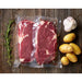 Eurodib smooth vacuum bag holding vacuum-packed raw steaks on a wood board with potatoes, garlic and rosemary