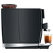 Jura GIGA 10 residential automatic coffee machine in black, right side view with bean hopper and a glass of coffee