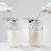 Jura glass milk carafe for automatic coffee machines, 16.9 oz, two carafes being filled with milk from bottles