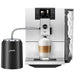 Jura Milk Glacette in black with milk pipe connected to a Jura coffee machine brewing a latte macchiato