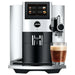 Jura S8 residential automatic coffee machine in chrome with touchscreen display, angled view with a glass of coffee