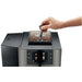 Jura X10 commercial automatic coffee machine, hand adjusting the grinder setting beside the bean container