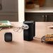 KitchenAid KHMR762BM matte black cordless hand mixer standing on a kitchen counter next to its battery