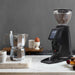 MACAP MI20 Touch Pro instant coffee grinder in black on a kitchen counter beside a moka pot and espresso cup