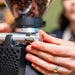 MACAP SUPRA 68 G Series coffee grinder in use, close-up of a hand adjusting the chrome portafilter holder