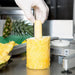 Nemco 55775 series Pineapple Corer/Peeler, close-up of a gloved hand lifting a peeled and cored pineapple