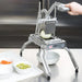 Nemco 56750 series Easy Onion Slicer 2 in use on a prep counter, slicing an onion into a white bowl