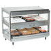 Nemco 6480 series heated pass through station, stainless steel with slanted shelves holding packaged hot food