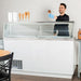 Nordic Air IDF-68 white ice cream dipping freezer in use, server scooping ice cream into a cone behind the counter
