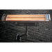 Omcan 31432 infrared patio heater glowing orange, mounted on a dark brick wall with black bracket, front view