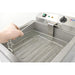 Omcan 44522 electric 120V 25 lb countertop donut fryer, hand lifting the wire mesh frying basket from the tank