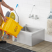 Phoenix MS-1620-6 stainless steel mop sink in use, worker emptying a yellow mop bucket into the bowl under a faucet