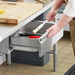 Phoenix TDR stainless steel work table drawer shown in use, open under a table with a butcher block top