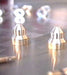 Potis propane conversion kit, close-up of two brass burner jets with threaded ends on a reflective surface