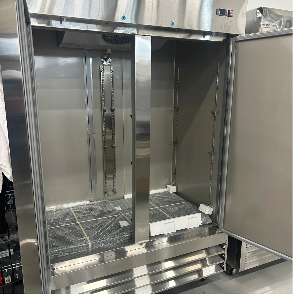 Open box Nordic Air SR-54 54-inch reach-in refrigerator with both doors open, showing the empty stainless interior