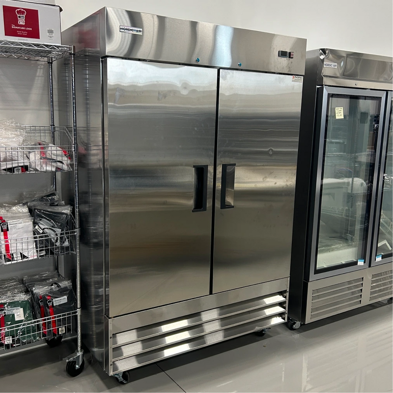 Open box Nordic Air SR-54 54-inch double solid door stainless steel refrigerator in the showroom, doors closed, angled
