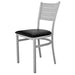 Tarrison Aria side chair with silver metal frame, slotted back and black vinyl padded seat, angled front view