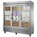 True T-72FG-HC~FGD01 78" wide three glass door display freezer on casters, stocked with boxed frozen products