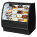 True TGM-R-48-SC/SC-B-W 48-inch black curved glass refrigerated pastry display case filled with cakes