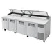 True TPP-AT-119-HC 119" four door stainless steel pizza prep table with lids raised and white cutting board