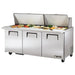 True TSSU-72-30M-B-ST-HC 72" mega top sandwich prep table with both split lids open over toppings, front view