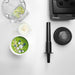 Vitamix 062828 drink blender shown from above with tamper, lid, container and green smoothie bowl on white counter