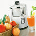 Waring 6001C heavy duty bar juice extractor with a glass of carrot juice and a basket of fresh fruit
