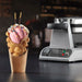 Waring WBW300X bubble waffle maker behind a bubble waffle cone filled with ice cream and toppings