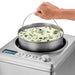 Waring WCIC25 2.5 quart ice cream maker, hand lifting the removable bowl of pistachio ice cream by its handle