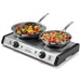 Waring WDB600 double cast-iron burner shown in use with two stainless sauté pans of vegetables and pasta