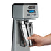 Waring WDM120TX single-spindle drink mixer, hand placing the stainless steel cup on the cup holder