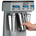 Waring WDM360TX triple spindle drink mixer, hand placing a stainless steel cup on the cup holder