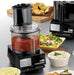 Waring WFP11S 2.5 quart food processor with clear bowl of tomato sauce beside plated appetizers and dips