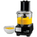 Waring WFP14S 3.5 quart food processor with clear bowl full of yellow soup beside a bowl of soup