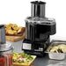 Waring WFP14SC 3.5 quart food processor with continuous feed chute beside sliced vegetables and bruschetta