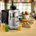 Waring WJX80X heavy duty juice extractor on a counter with fresh juices, apples, carrots and cucumber