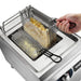 Waring WPC100 electric pasta cooker, close-up of a hand lifting a rectangular basket of cooked pasta from water