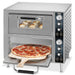Waring WPO750 double deck double door oven with lower door open, pizza on a peel and rolls baking on top deck