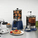 Waring WSD1G 1-gallon syrup dispensers shown on a breakfast counter beside waffles, pancakes and fruit