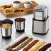 Waring WSG30 heavy duty spice grinder shown with ground spices, bowls of whole spices and extra grinding cups
